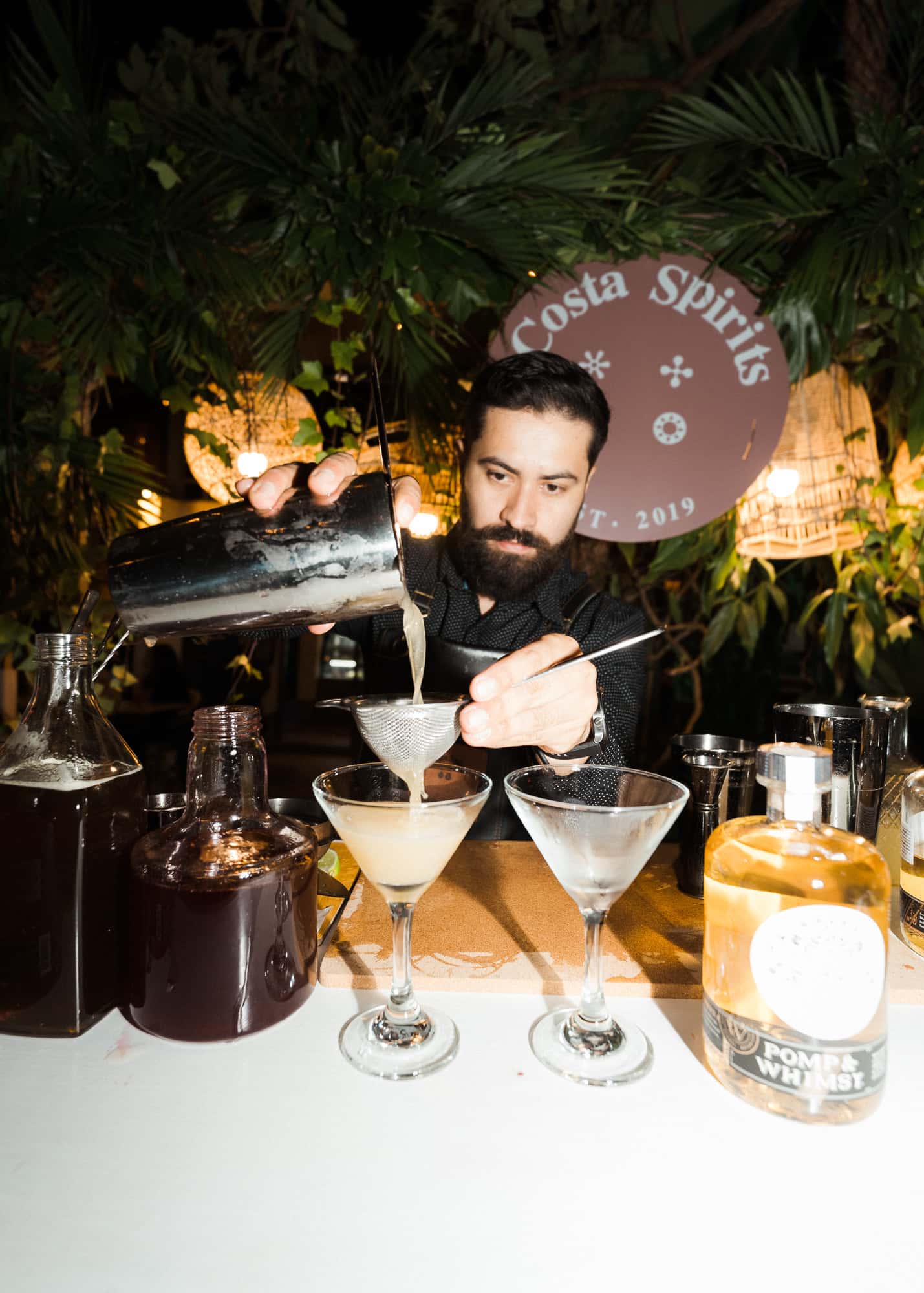 Bartender sirviendo dos coupes en un evento de Costa Spirits