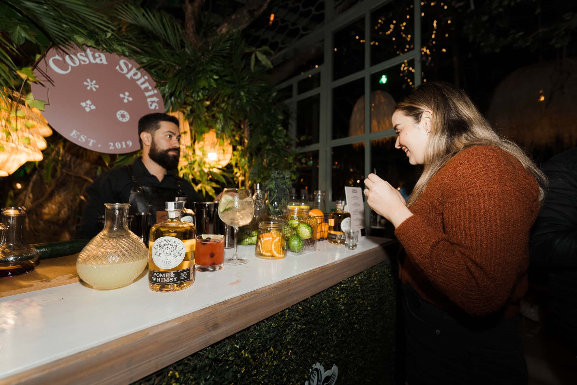 A Costa Spirits bartender serving a guest